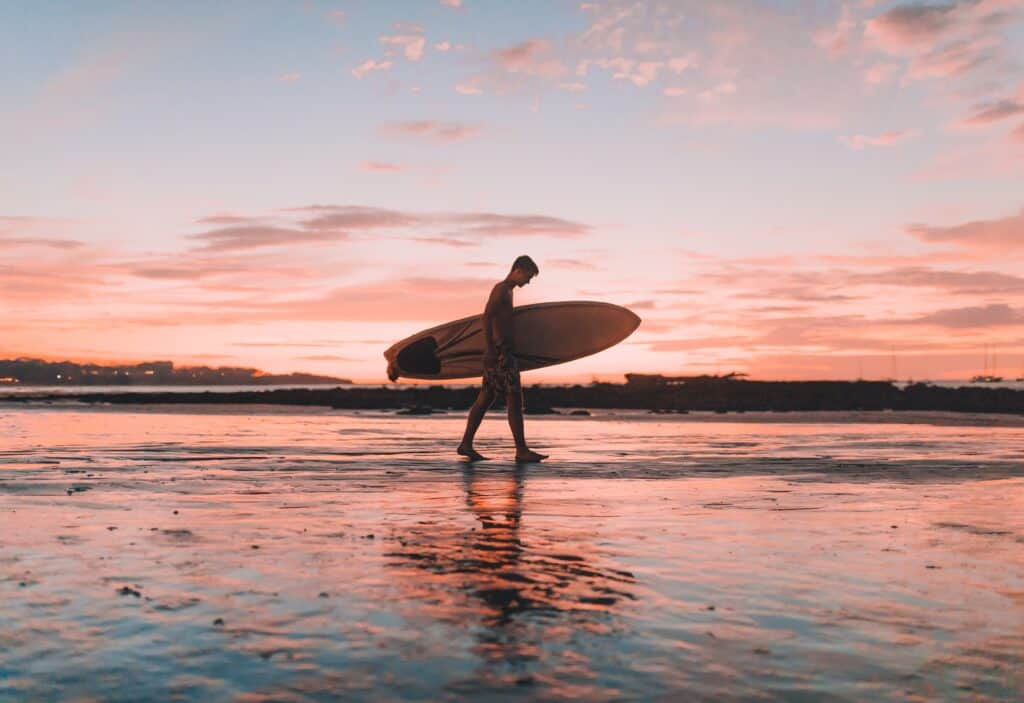 urge surfing, man on beach with surf board, sea